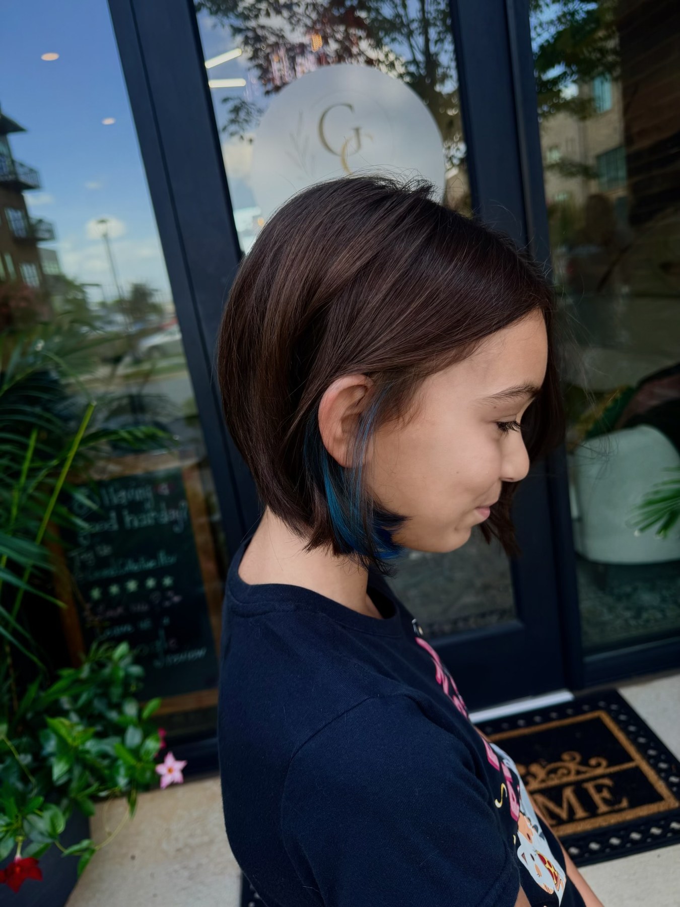 Short brunette haircut with blue accent color by Dakota Coone