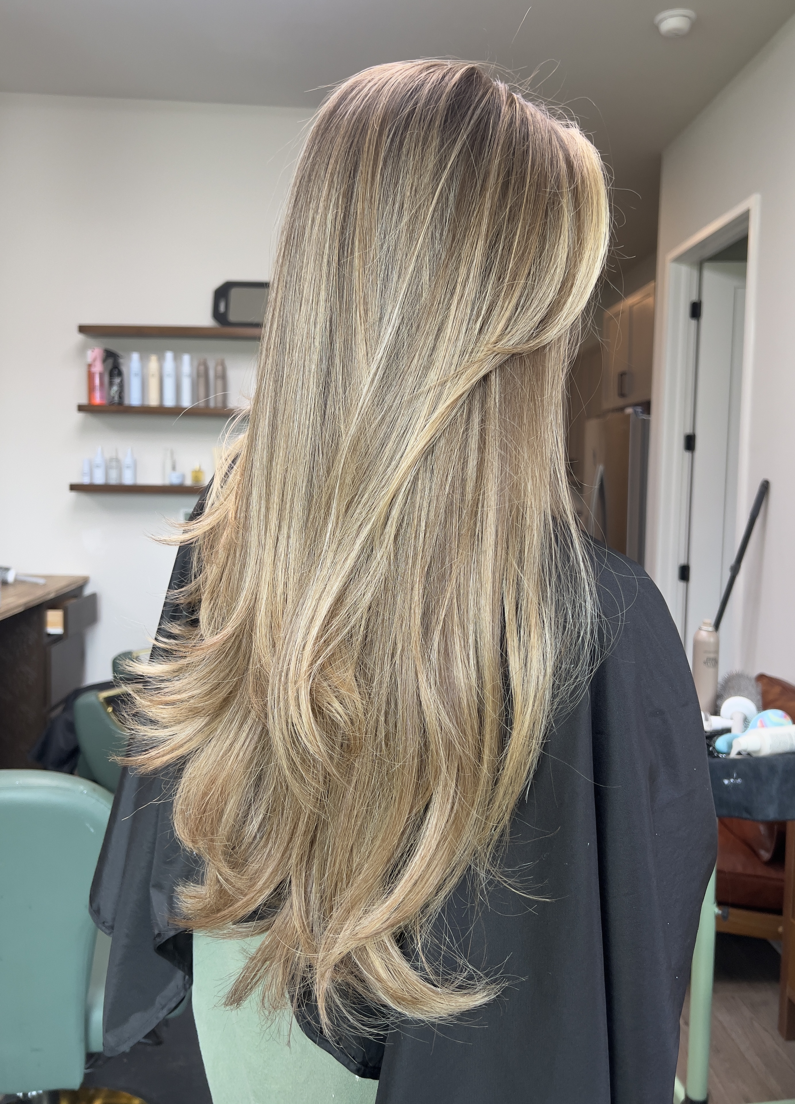 Long layered blonde haircut by Emilee Anderson